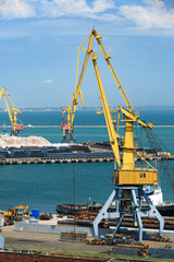 Fototapeta premium industrial seaport infrastructure, sea, cranes and raw materials, metal structures and ship, the concept of marine cargo transportation