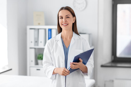 medicine, healthcare and profession concept - smiling female doctor with clipboard at hospital