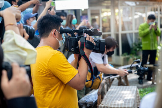 Videographer use camcorder with camera in shooting process. and blur of group people in background with free copy space for your text.