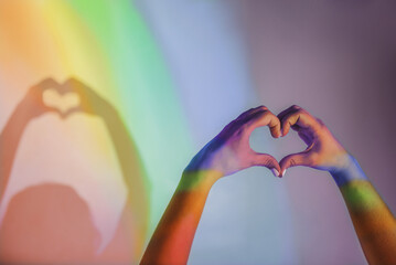 Gay pride concept. Handmade Heart Sign with Gay Pride LGBT. female hands show a heart-shaped figure...