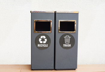 Two gray trash cans with general waste and recycling.