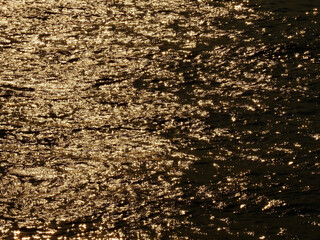 water wave in the river with reflection of sunlight at sunset
