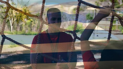 Animation of flag of argentina over caucasian man and boy during obstacle race training - Powered by Adobe