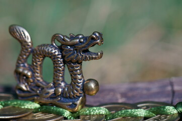 Fototapeta na wymiar Dragon figurine with Chinese coins. A religious symbol. Feng shui figurines.