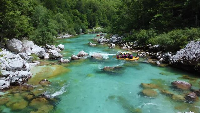 Soca Valley, Slovenia - 4K Aerial shot of white water rafting on River Soca. Following whitewater rafting boat going down the emerald alpine river Soca on a bright summer day
