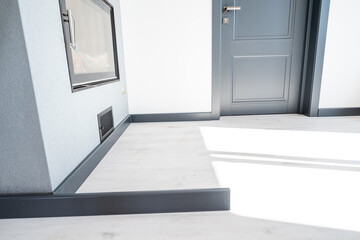 The plinth is dark gray to match the color of the door, mounting the plinth in the room.