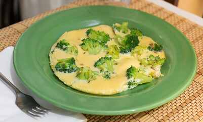 wholesome breakfast. omelet with broccoli on green plate