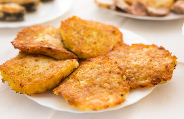 Fried grated potato pancakes with sour cream on white plate