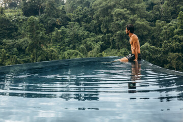 Man sitting on the edge of infinity pool at resort