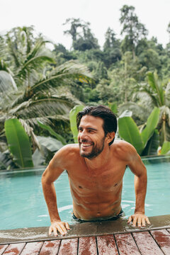 Smiling Young Man Coming Out Of Swimming Pool