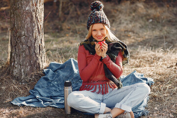 Girl sitting by the tree in a spring forest