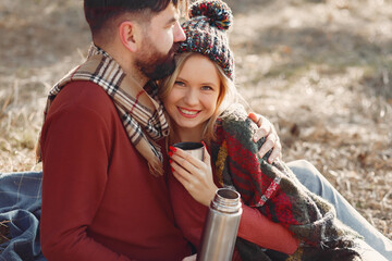 Couple sitting by the tree in a spring forest