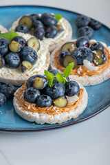 Open sandwich with blueberries. Made from rice crispbreads and peanut butter, healthy nutritious snack option, vegan food