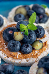 Open sandwich with blueberries. Made from rice crispbreads and peanut butter, healthy nutritious snack option, vegan food
