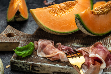 Cantaloupe melon with ham prosciutto jamon. Spanish and Italian snack antipasti appetizer. banner, menu, recipe