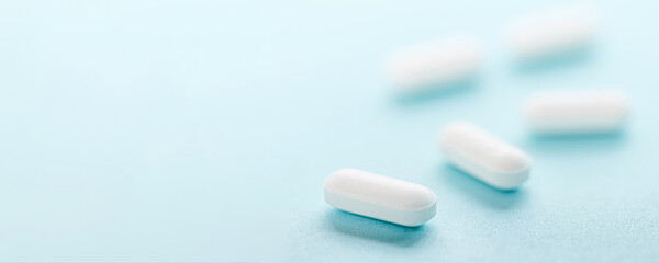 White pills isolated on blue background