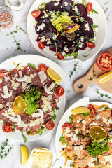 set of carpaccio Salmon, beetroot and Beef Carpaccio with parmesan, capers and arugula. vertical image. top view. place for text