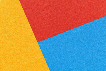 Fototapeta premium Texture of craft yellow, blue and bright red shade color paper background, macro. Abstract cardboard