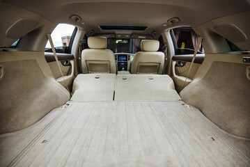 Luxury car boot with folded seats. Opened empty car trunk. Clean trunk of the SUV. Organization of space in the trunk of the car