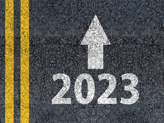 happy new year 2023 Year 2023 and an arrow written on an asphalt road

