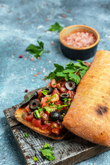 Italian ciabatta with chopped tomato vegetables. vertical image. top view. place for text