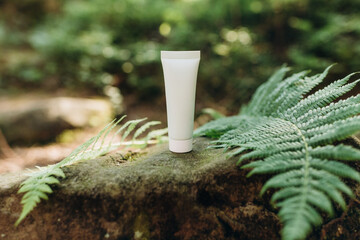 Mockup of a tube for cream on a natural background in the forest, an environmentally friendly...