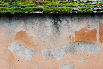 vue frontale d'un vieux mur décrépi avec des pierres moussues. Un vieux mur avec de la mousse...
