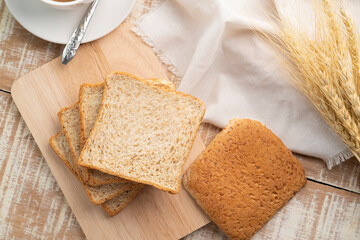 Sliced whole wheat bread on wooden cutting board,healthy food concept.Top view - obrazy, fototapety, plakaty