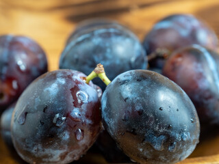 Fresh juicy plums. Plums on a wooden background.