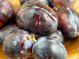 Fresh juicy plums. Plums on a wooden background.