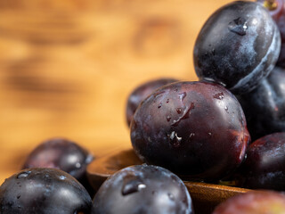 Fresh juicy plums. Plums on a wooden background.