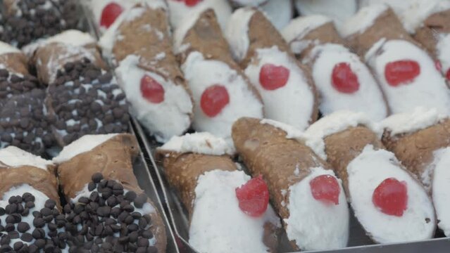 various Sicilian cannoli with chocolate flakes and candied cherry filled with ricotta cheese