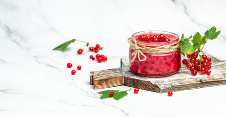 red currant jam with fresh berry. Canned berries on a light background. Long banner format