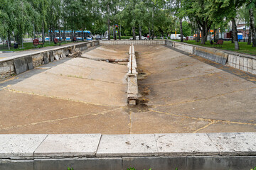 Repair of the old city fountain without water. Destroyed walls, pipes and the bottom of the old...