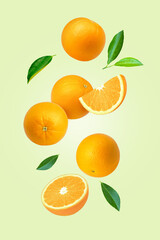 Orange fruit with cut half slice and green leaf flying in the air isolated on color background.