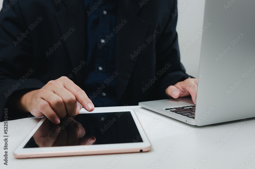 Poster businessman with a touch tablet and a laptop computer searches for information with internet technol