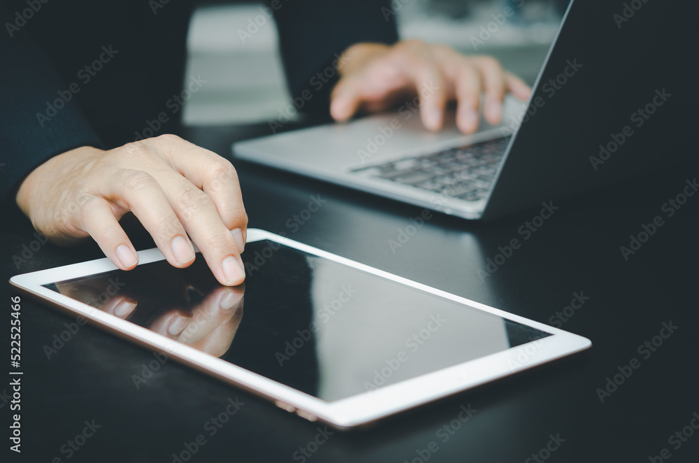 Poster businessman with a touch tablet and a laptop computer searches for information with internet technol