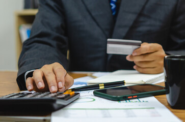 Fototapeta premium employee of a company paying a charge with a credit card while conducting internet shopping. Concept of tax and accounting in business.