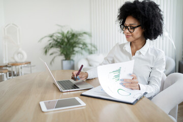 Report manager woman working in office in uses laptop in finance company