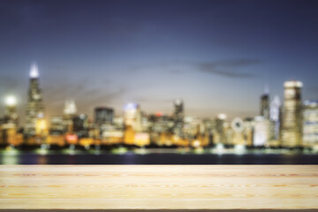 Fototapeta na wymiar Empty table top made of wooden dies with blurry city view at dusk on background, template