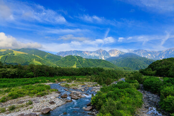 夏の美しい白馬村の松川から見える五竜岳と雪渓
