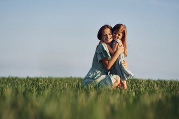 Moment of tenderness. Mother and daughter have fun outdoors on the field at summer