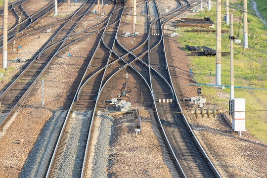 A railway junction with crossing parallel railroad tracks. Perspective view of railway tracks interchanges. Concept of choosing a path or route. Industrial background. Top view