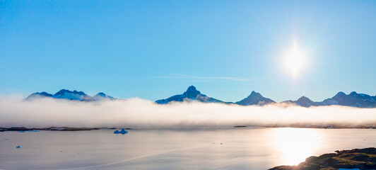 Arctic landscape of Greenland in Summer. Beautiful view of mountains with Snowy peaks and misty mountains