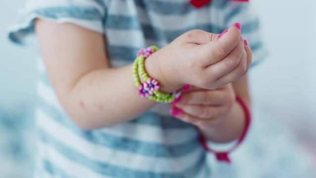 Girl unsuccessfully trying to put on wristlet