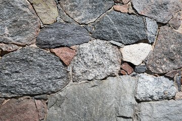 Stone wall with different colors and size of rocks