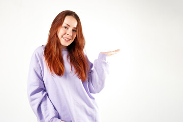 Caucasian woman in violet sweatshirt. Natural look. Smiling. long red hair. White background