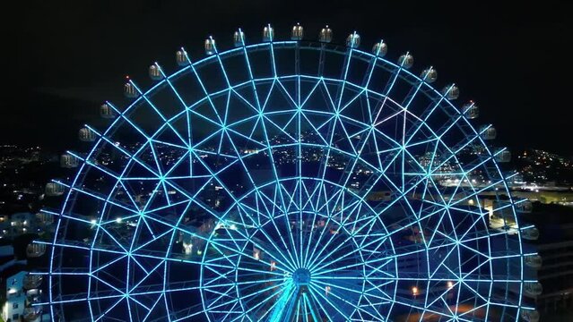 Rio de Janeiro, Brazil - August 3, 2022: Aerial view of Yup Star (Rio Star) ferris wheel at night is illuminated with colorful RGB led lights.