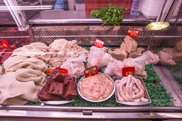 showcase of a butcher shop with lamb heads and offal for sale in a public market in Barcelona