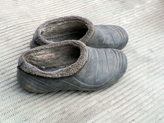 Dirty black rubber galoshes on a white background. Closeup